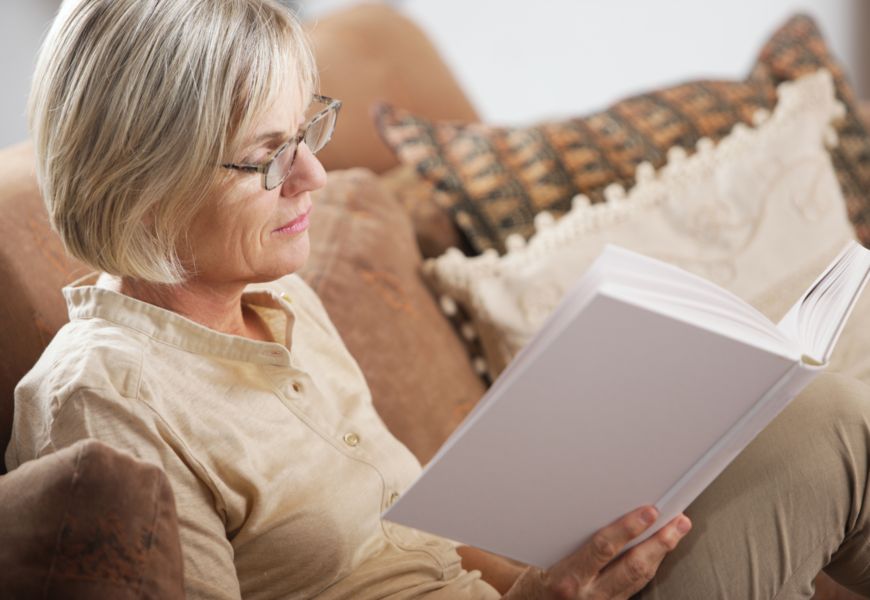 Женщина в возрасте читает книгу